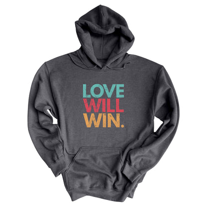 Dark Heather color hoodie with a graphic that says “Love will win.” in all caps. Each word is on its own line and is a different color. “Love” is greenish-blue, “Will” is red, and “Win.” is yellow. The graphic has a faded and slightly grungy/worn look.