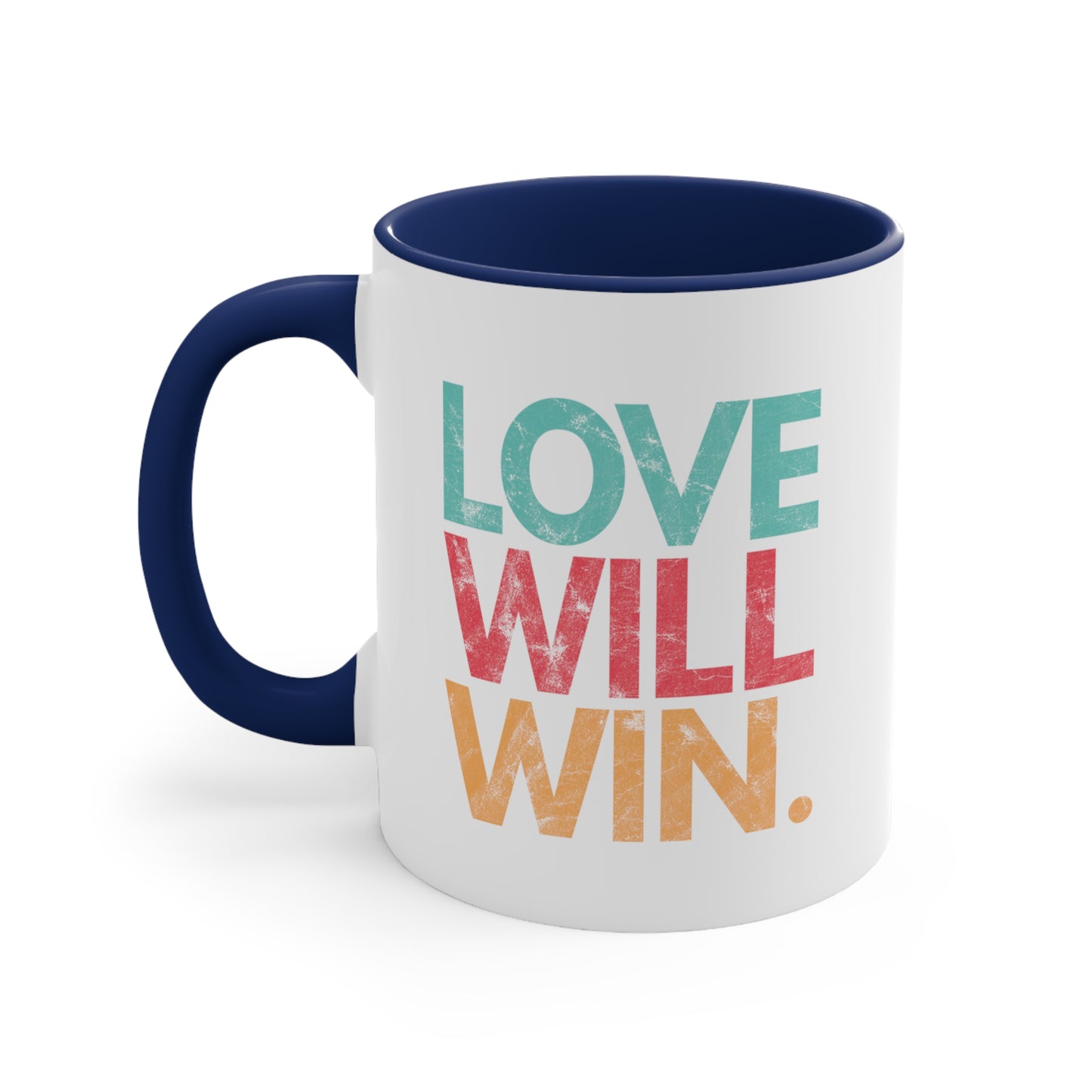 11oz ceramic mug with a navy blue handle and interior with a graphic that says “Love will win.” in all caps. Each word is on its own line and is a different color. “Love” is greenish-blue, “Will” is red, and “Win.” is yellow. The graphic has a faded and slightly grungy/worn look.