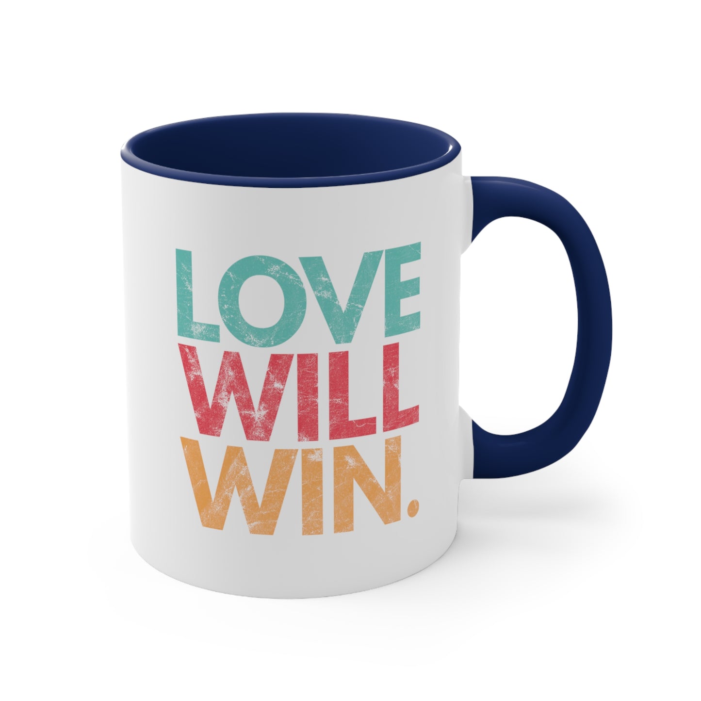 11oz ceramic mug with a navy blue handle and interior with a graphic that says “Love will win.” in all caps. Each word is on its own line and is a different color. “Love” is greenish-blue, “Will” is red, and “Win.” is yellow. The graphic has a faded and slightly grungy/worn look.