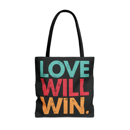 Black tote bag with a graphic that says “Love will win.” in all caps. Each word is on its own line and is a different color. “Love” is greenish-blue, “Will” is red, and “Win.” is yellow. The graphic has a faded and slightly grungy/worn look.