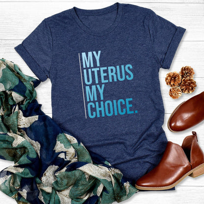 Heather Navy color unisex t-shirt that says, “My Uterus My Choice.” The text is in a blue gradient, and each word is on its own line. There is a light, thin vertical line along the left side of the text.