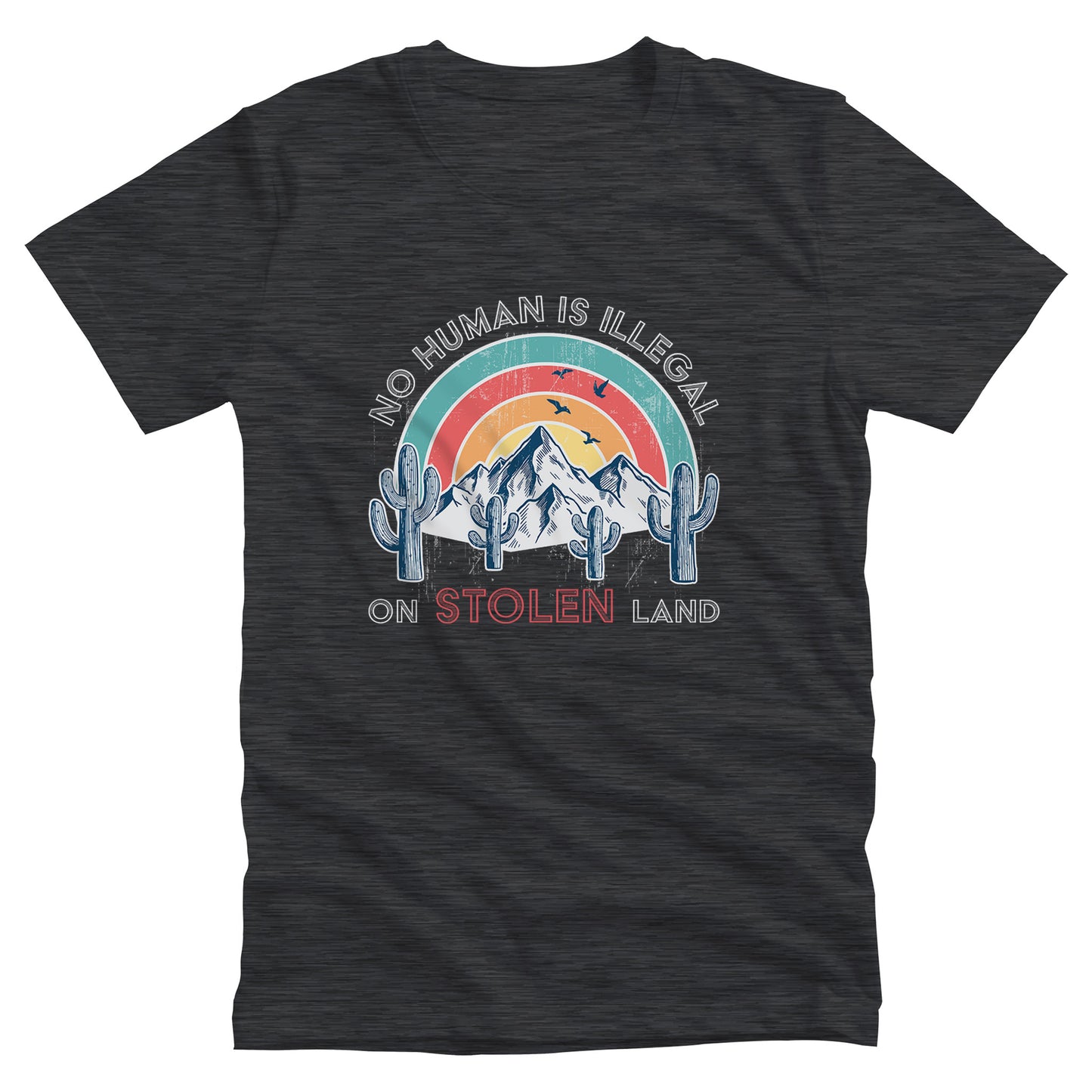 Dark Grey Heather color unisex t-shirt that says, “No Human is Illegal on Stolen Land” arched over a retro sunset with mountains and cactuses in the front. “No Human is Illegal” is arched over the top of the graphic and “on Stolen Land” is on one horizontal line beneath the graphic. The whole image is slightly distressed.