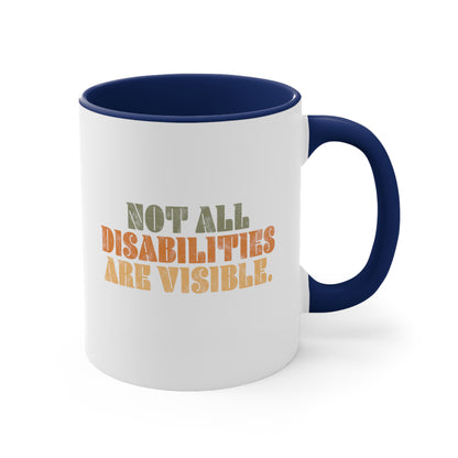 11oz ceramic mug with a navy blue interior and handle that says, “Not all disabilities are visible” in a thick, retro font in all caps. Each line is a different color. “Not all” is light green, “disabilities” is orange, and “are visible” is yellow. The graphic has a retro look and is slightly distressed.