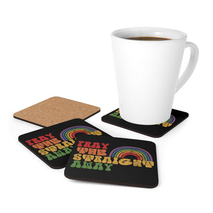 Contextual photo of four black 3.75x3.75” cork-backed coasters that say “PRAY THE STRAIGHT AWAY” in a retro font. Each word is a different retro color and on its own line. “PRAY” is maroon, “THE” is orange, “STRAIGHT” is yellow, and “AWAY” is green. The words are stacked and left-aligned with a rainbow graphic that has matching colors nestled after the word “THE” over the word “STRAIGHT.” 