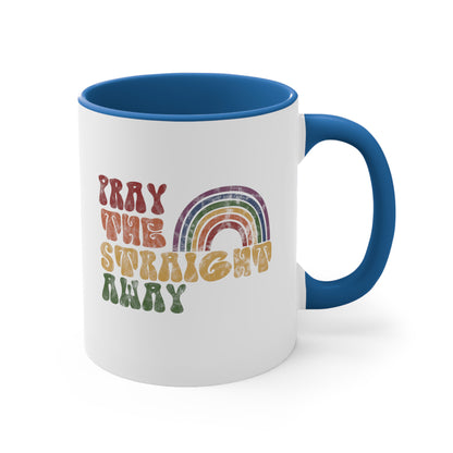 11oz ceramic mug with a blue interior and handle that says, “PRAY THE STRAIGHT AWAY” in a retro font. Each word is a different retro color and on its own line. “PRAY” is maroon, “THE” is orange, “STRAIGHT” is yellow, and “AWAY” is green. The words are stacked and left-aligned with a rainbow graphic that has matching colors nestled after the word “THE” over the word “STRAIGHT.”