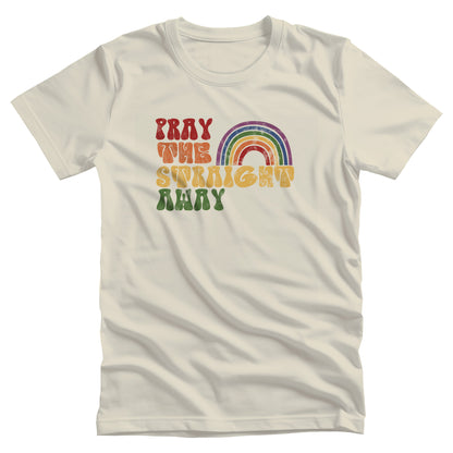 Natural color unisex t-shirt that says, “PRAY THE STRAIGHT AWAY” in a retro font. Each word is a different retro color and on its own line. “PRAY” is maroon, “THE” is orange, “STRAIGHT” is yellow, and “AWAY” is green. The words are stacked and left-aligned with a rainbow graphic that has matching colors nestled after the word “THE” over the word “STRAIGHT.”