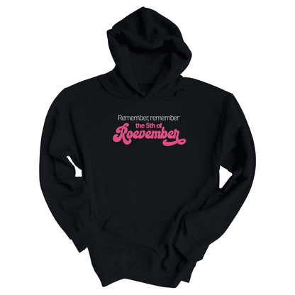 Black color hoodie featuring the phrase 'Remember, Remember the 5th of Roevember'. The text 'The 5th of Roevember' is highlighted in pink, embellished with a decorative script font and additional swooshes.