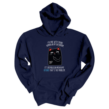 Navy Blue unisex hoodie with a graphic of an annoyed cat showing its middle finger. The text says “I’m fine with trans women in my bathroom” above the graphic, slightly arched. Below the graphic reads “It’s Republican men in my uterus that’s the problem.”