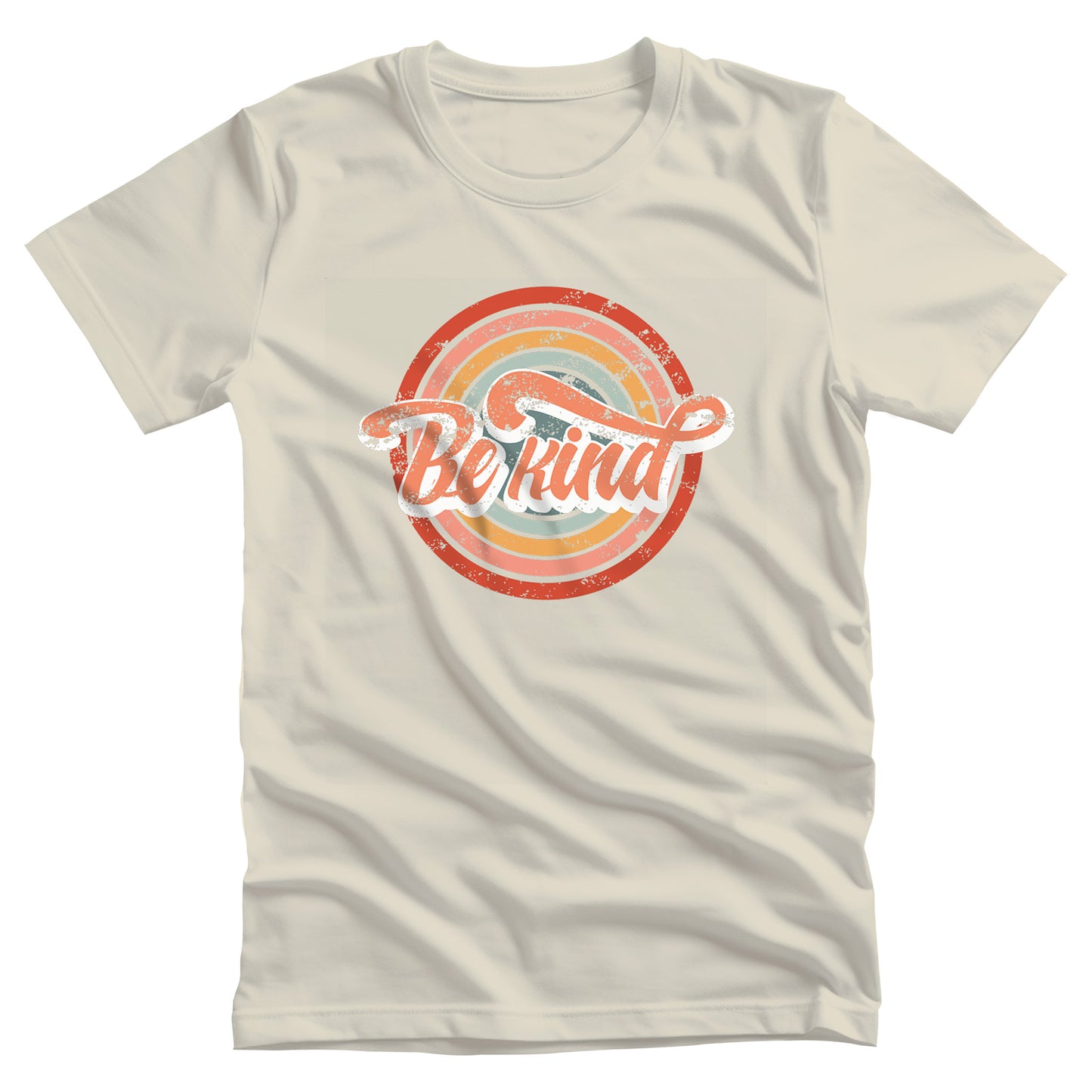 Natural  color unisex t-shirt with a graphic that says “Be Kind.” There is a retro-colored circular rainbow behind it. The text is outlined in white and has a long swoosh that swirls from the end of the letter “d” across the entire word “kind.”