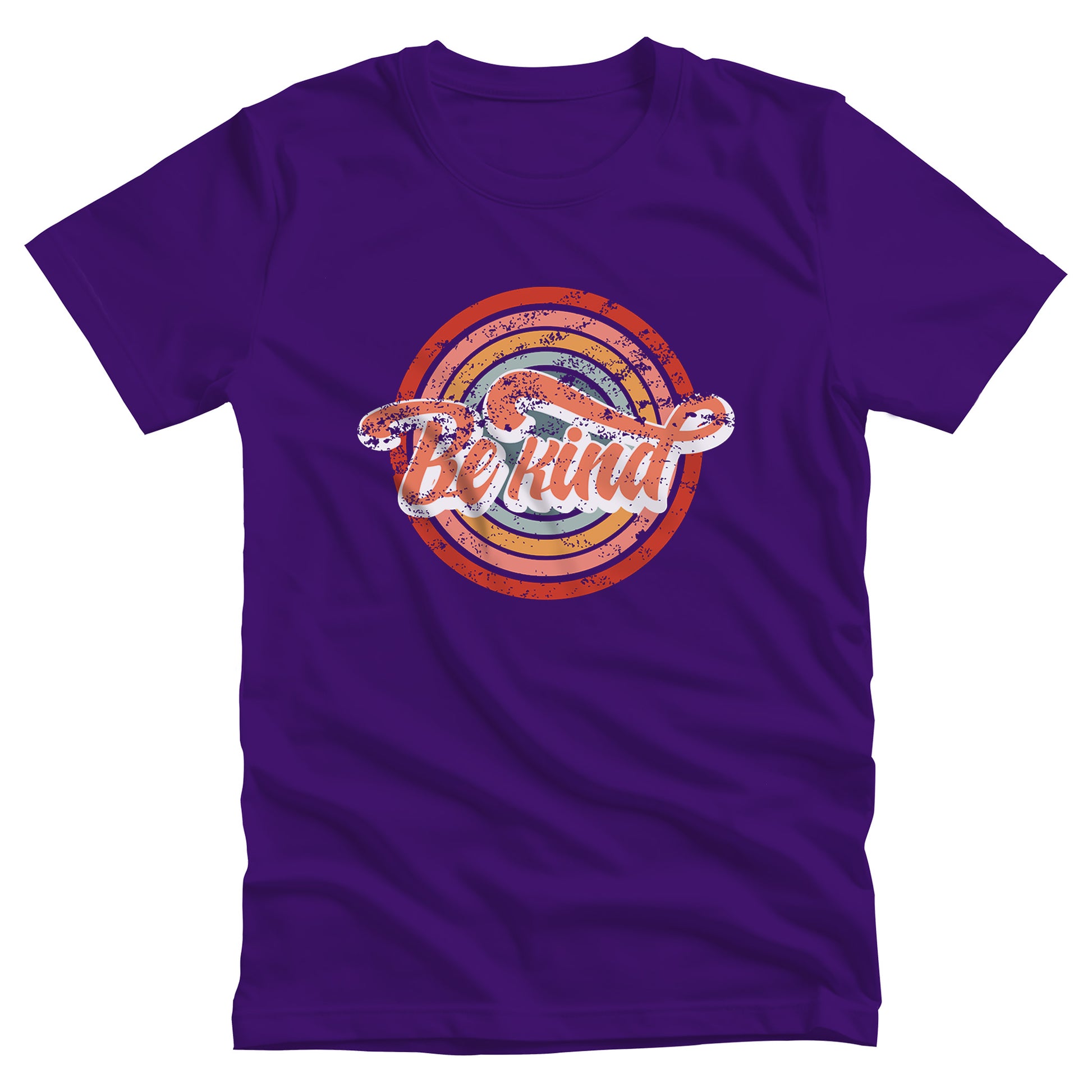 Team Purple color unisex t-shirt with a graphic that says “Be Kind.” There is a retro-colored circular rainbow behind it. The text is outlined in white and has a long swoosh that swirls from the end of the letter “d” across the entire word “kind.”