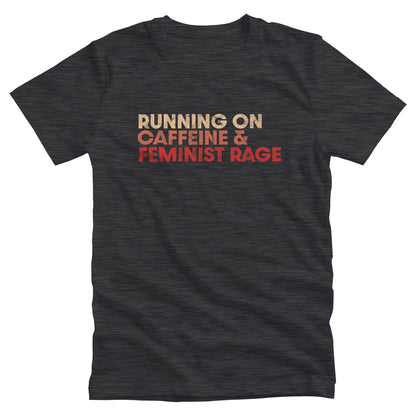 Dark Grey Heather color unisex t-shirt that says, “RUNNING ON CAFFEINE & FEMINIST RAGE” with each line being a different color. “RUNNING ON” is a beige color, “CAFFEINE &” is a reddish-pink color, and “FEMINIST RAGE” is red. The text is slightly distressed.