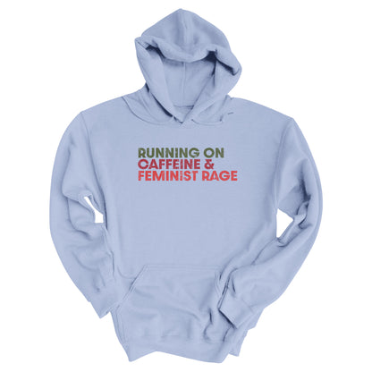 Light Blue color unisex t-shirt that says, “RUNNING ON CAFFEINE & FEMINIST RAGE” with each line being a different color. “RUNNING ON” is dark green, “CAFFEINE &” is dark red, and “FEMINIST RAGE” is dark orange. The text is slightly distressed.