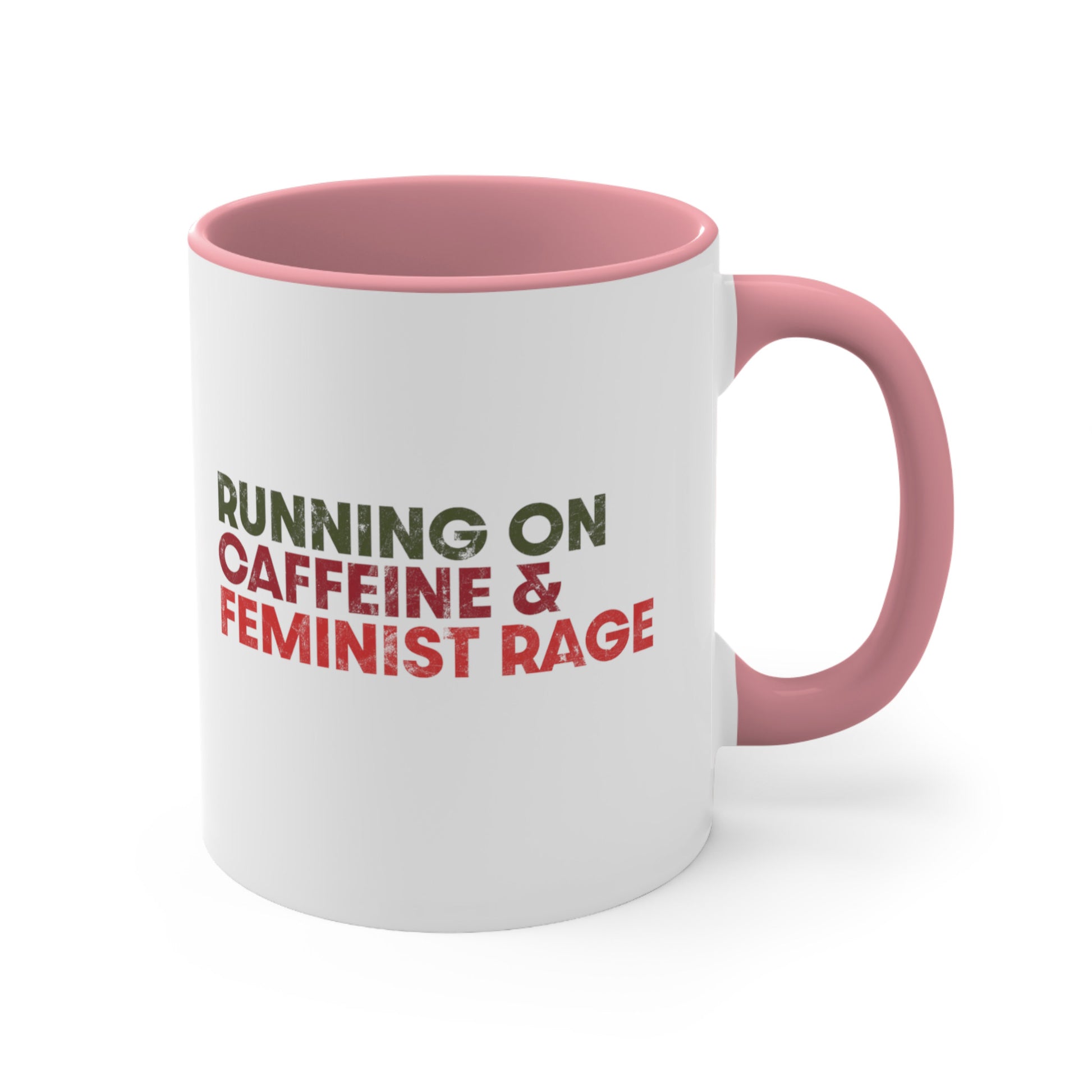 11oz ceramic mug with a pink interior and handle color that says, “RUNNING ON CAFFEINE & FEMINIST RAGE” with each line being a different color. “RUNNING ON” is dark green, “CAFFEINE &” is dark red, and “FEMINIST RAGE” is dark orange. The text is slightly distressed.