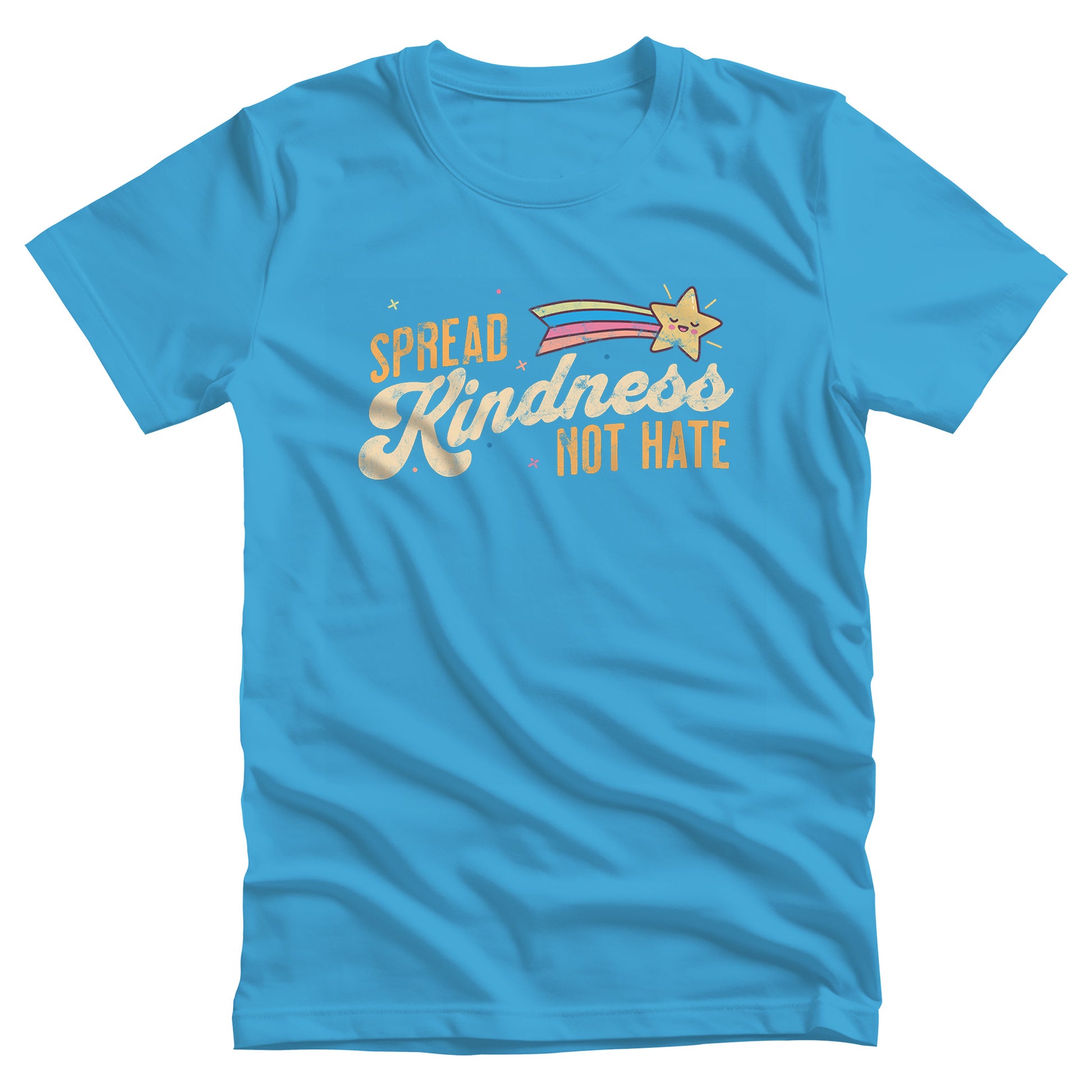 Aqua color unisex t-shirt with a graphic that says “Spread Kindness Not Hate” with an illustration of a rainbow shooting star over the word “kindness.” That word is in a script font, and the rest is a regular font in all caps. ”Spread” is on top of the word “Kindness” and aligned left, while “Not Hate” is below the word “kindness” and aligned to the right.