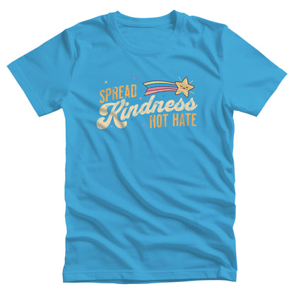 Aqua color unisex t-shirt with a graphic that says “Spread Kindness Not Hate” with an illustration of a rainbow shooting star over the word “kindness.” That word is in a script font, and the rest is a regular font in all caps. ”Spread” is on top of the word “Kindness” and aligned left, while “Not Hate” is below the word “kindness” and aligned to the right.