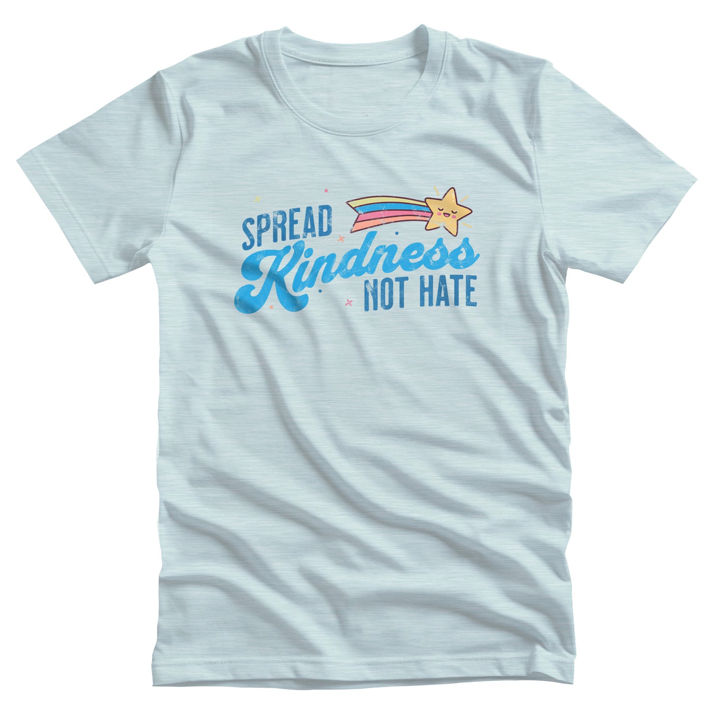 Heather Ice Blue color unisex t-shirt with a graphic that says “Spread Kindness Not Hate” with an illustration of a rainbow shooting star over the word “kindness.” That word is in a script font, and the rest is a regular font in all caps. ”Spread” is on top of the word “Kindness” and aligned left, while “Not Hate” is below the word “kindness” and aligned to the right.