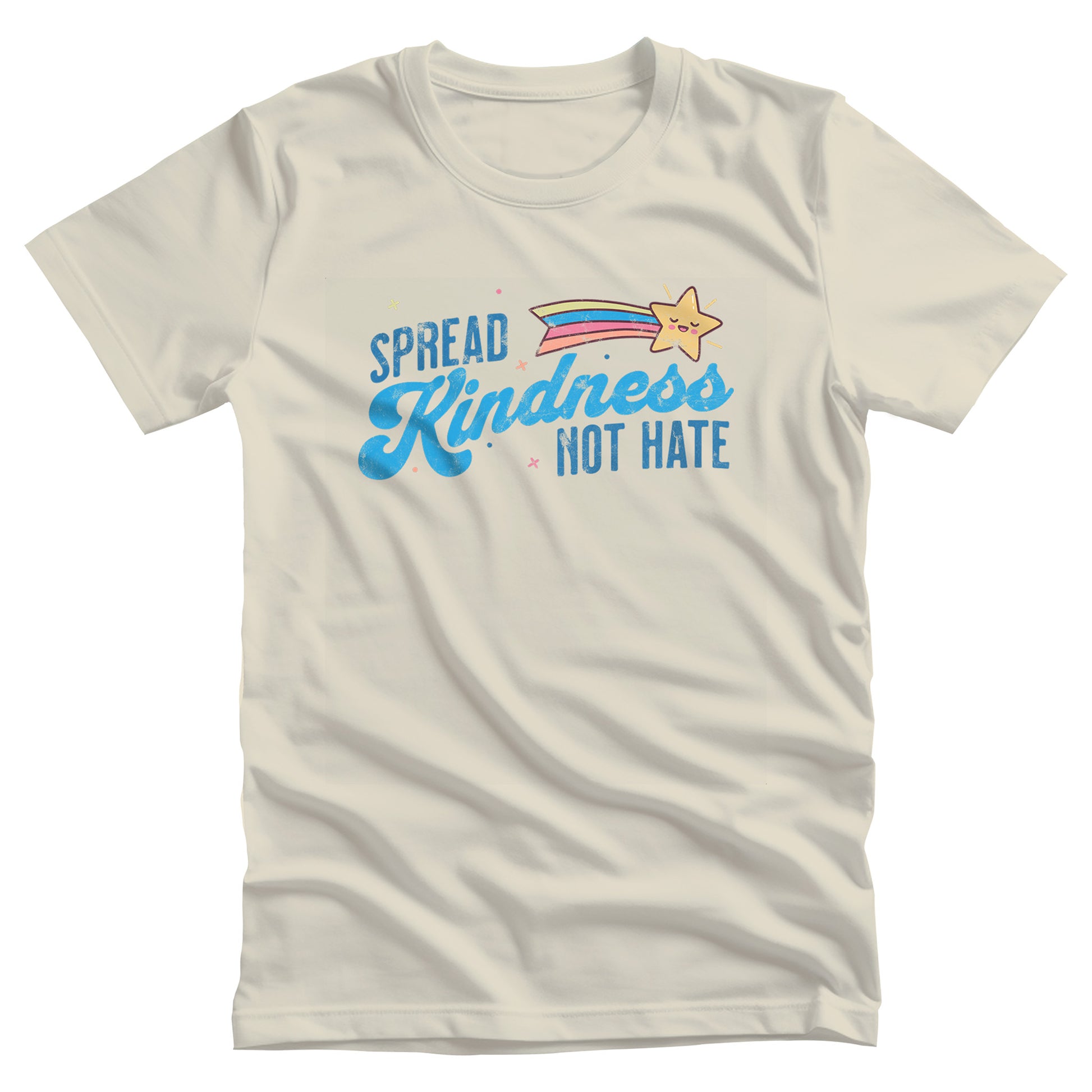 Natural color unisex t-shirt with a graphic that says “Spread Kindness Not Hate” with an illustration of a rainbow shooting star over the word “kindness.” That word is in a script font, and the rest is a regular font in all caps. ”Spread” is on top of the word “Kindness” and aligned left, while “Not Hate” is below the word “kindness” and aligned to the right.