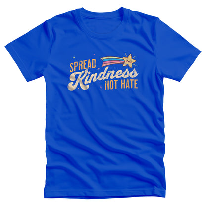 True Royal color unisex t-shirt with a graphic that says “Spread Kindness Not Hate” with an illustration of a rainbow shooting star over the word “kindness.” That word is in a script font, and the rest is a regular font in all caps. ”Spread” is on top of the word “Kindness” and aligned left, while “Not Hate” is below the word “kindness” and aligned to the right.