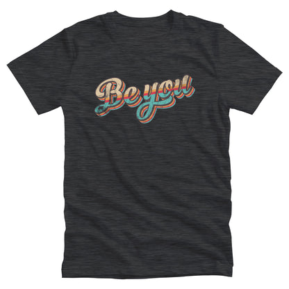 Dark Grey Heather color unisex t-shirt that says “Be you” in a vintage-inspired script font with vintage colors and stripes. It’s designed to look as if the design is wearing off the shirt.