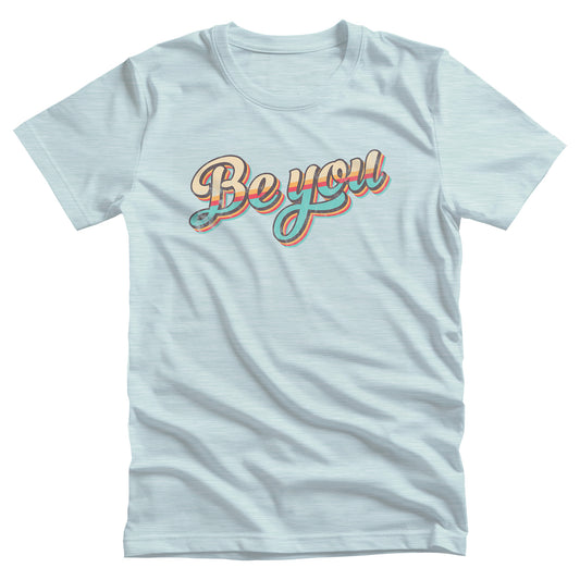 Heather Ice Blue color unisex t-shirt that says “Be you” in a vintage-inspired script font with vintage colors and stripes. It’s designed to look as if the design is wearing off the shirt.