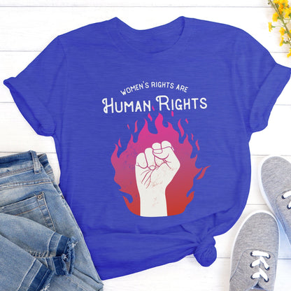 True Royal color unisex t-shirt with a graphic of a fist over pink and red flames. The text says, “Women’s rights are human rights” with the words “women’s rights are” arched over the words “Human Rights”.