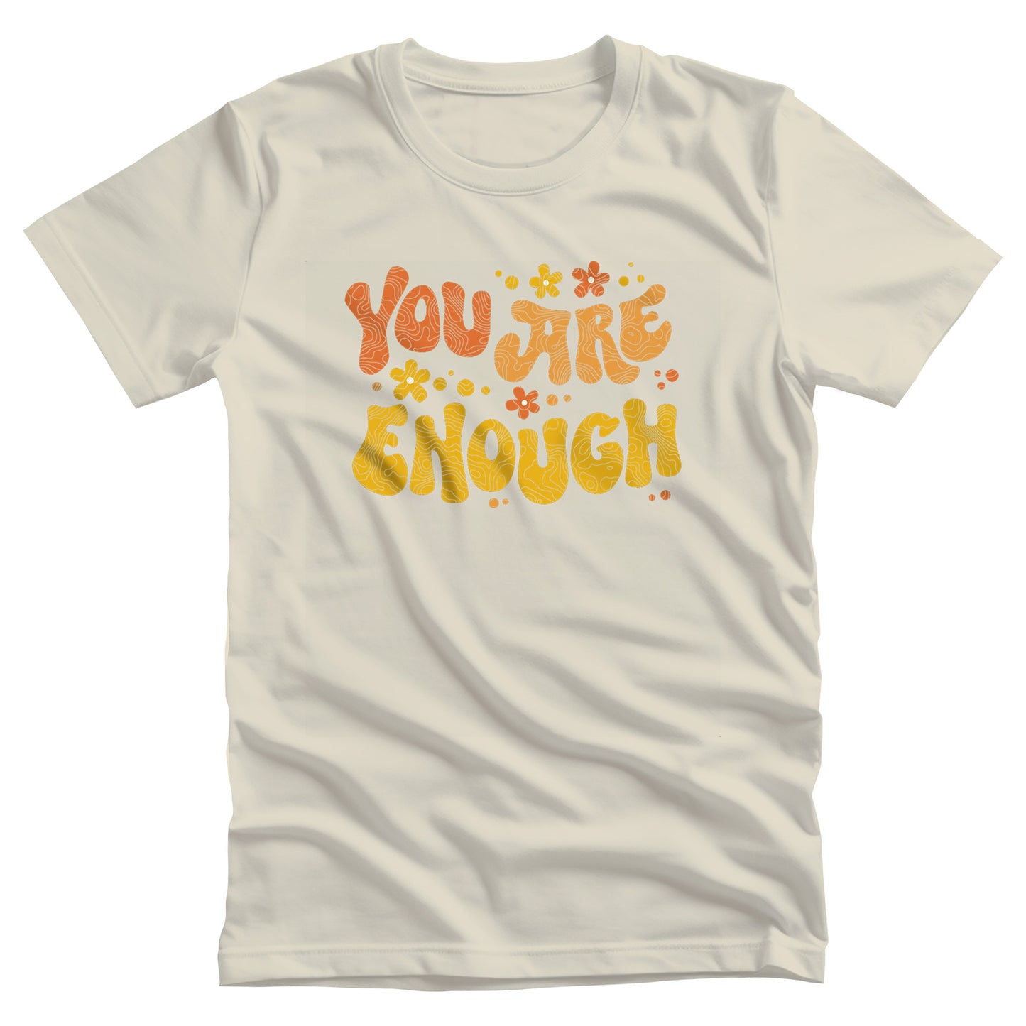Natural color unisex t-shirt with a graphic that says “You Are Enough” in a retro font. There are small retro flowers spaced throughout. “You” is reddish-orange, “Are” is orange, and “Enough” is yellow, all retro as well.