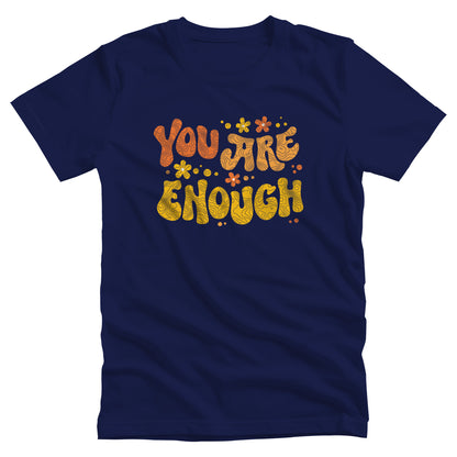 Navy Blue unisex t-shirt with a graphic that says “You Are Enough” in a retro font. There are small retro flowers spaced throughout. “You” is reddish-orange, “Are” is orange, and “Enough” is yellow, all retro as well.